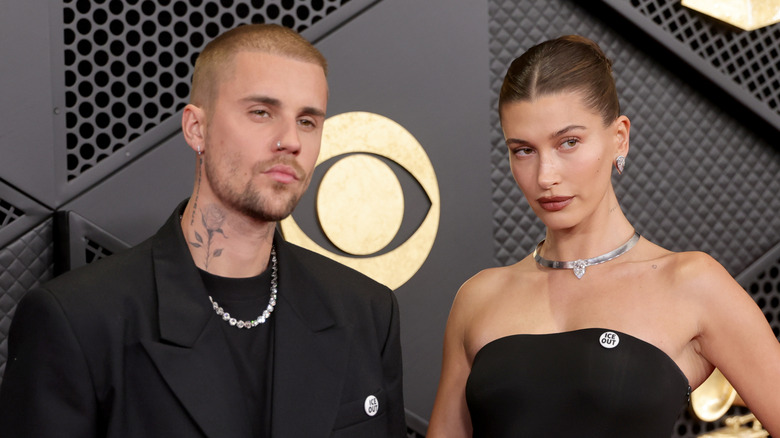 Justin Bieber gives the camera a cold stare, while Hailey Baldwin poses at an angle.