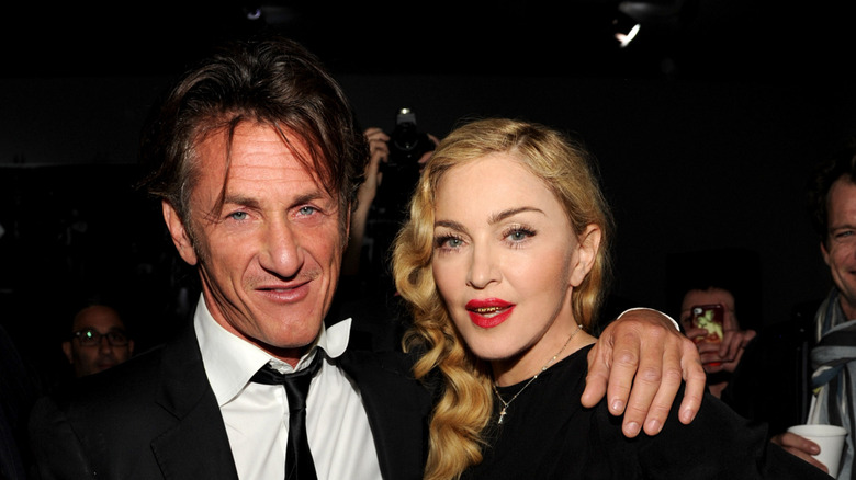 Sean Penn gives the camera a gentle smile as his arm is wrapped around pop star Madonna.