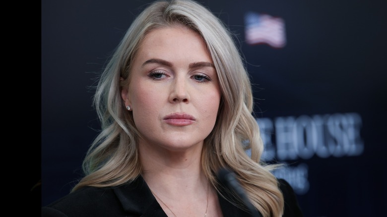 Wearing overdrawn eyebrows with blocky edges, Karoline Leavitt looks downward.