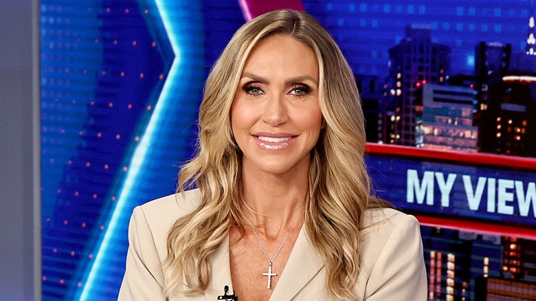 Sporting an unflattering cut crease, Lara Trump displays a wide smile.