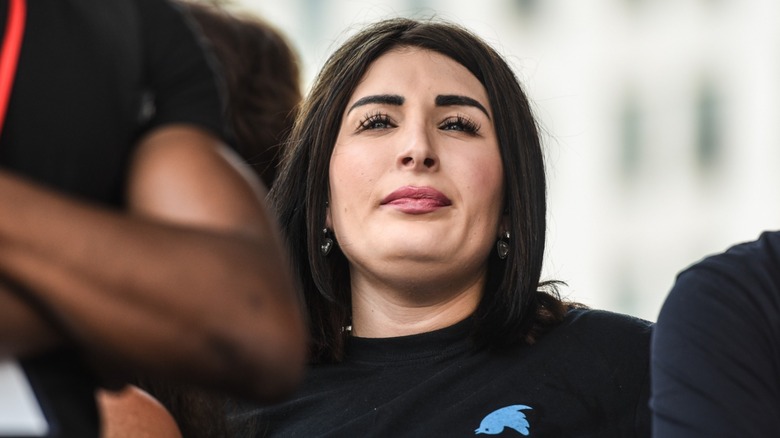 Sporting uneven eyebrows and pink lipstick, Laura Loomer gazes upward.