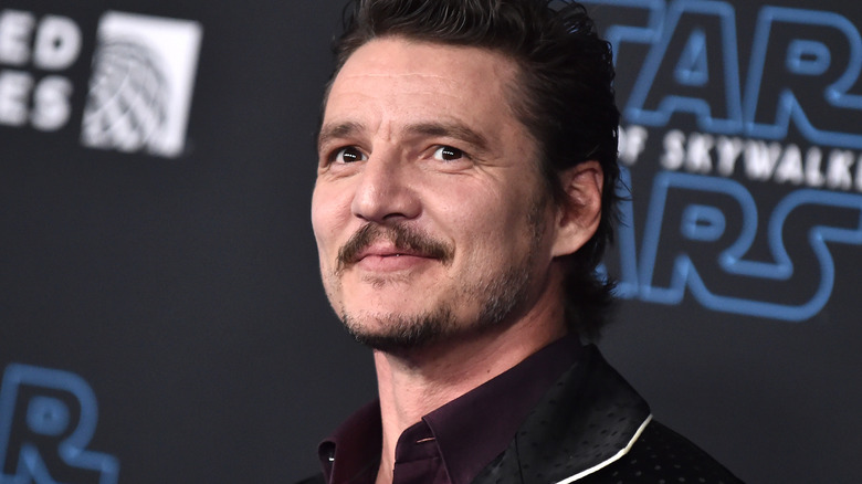 Pedro Pascal looking up, smiling