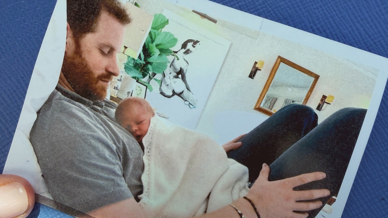 Newborn Archie lies on Prince Harry's chest.