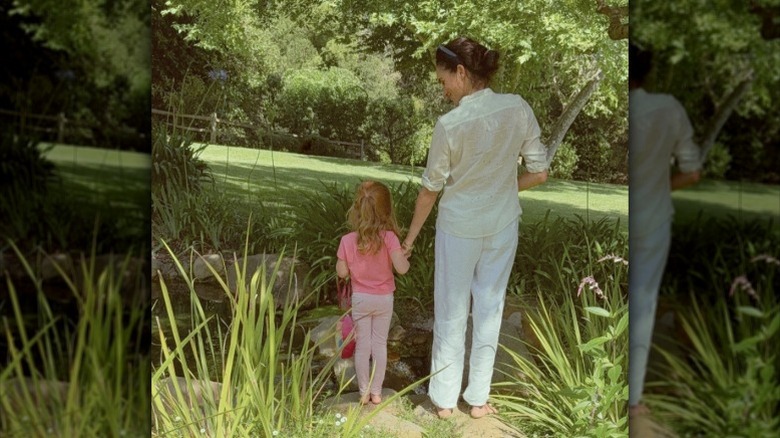 Meghan Markle and Lilibet holding hands.