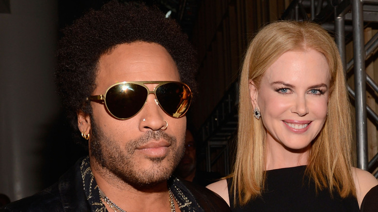 Lenny Kravitz and Nicole Kidman posing on a red carpet in front of a dark background