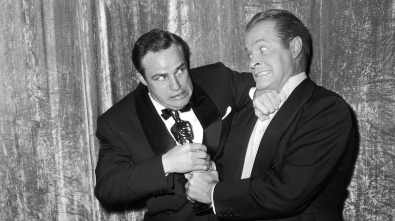 Marlon Brando and Bob Hope jokingly wrestle over Brando's Oscar statuette in 1955