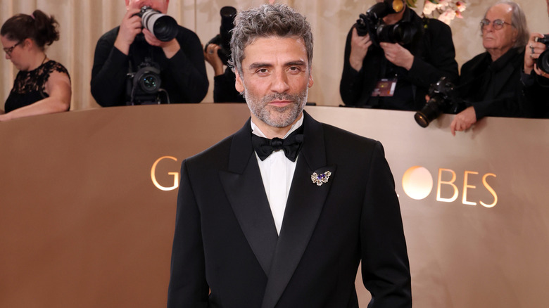 Oscar Isaac posing on the Golden Globes red carpet