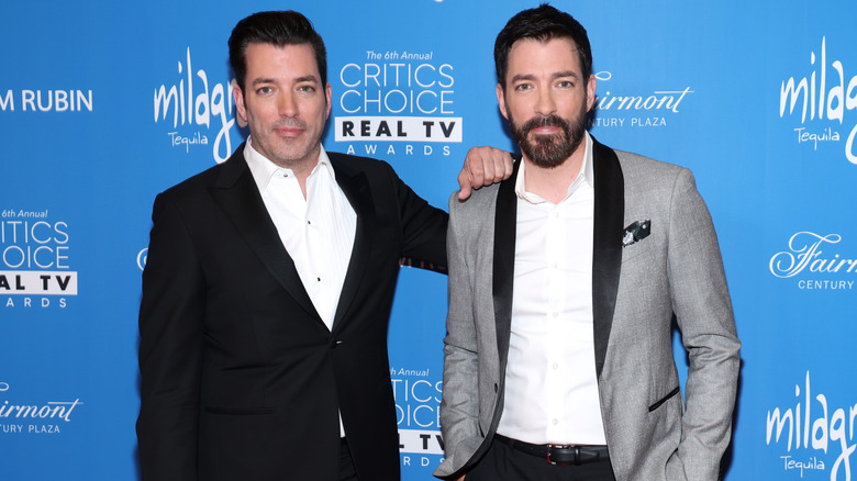 Jonathan's hand on Drew Scott's shoulder