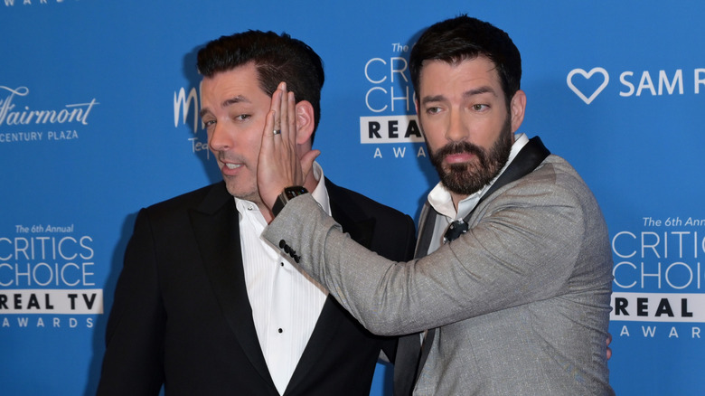 Drew Scott palming Jonathan's face