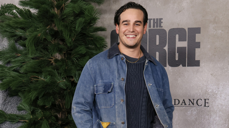 Alberto Rosende poses in front of a tree and backdrop