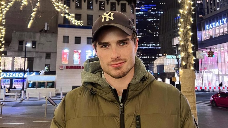 Michael Bradway smiling in coat in front of trees with lights