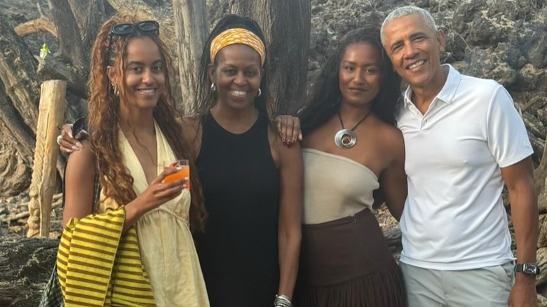 Sasha Obama displays a soft smile in a group photo with her family.