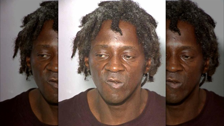 Flavor Flav scowling in mugshot