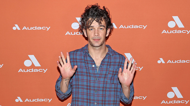 Matt Healy with his hands up