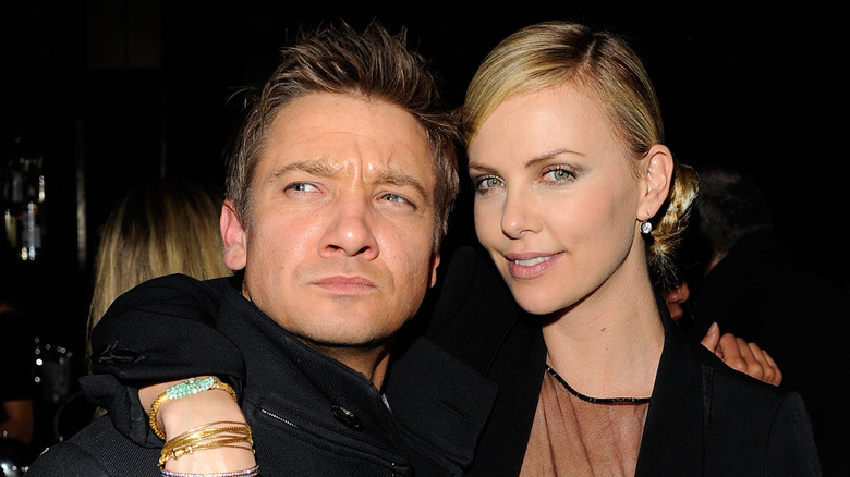 Charlize Theron with arm around Jeremy Renner