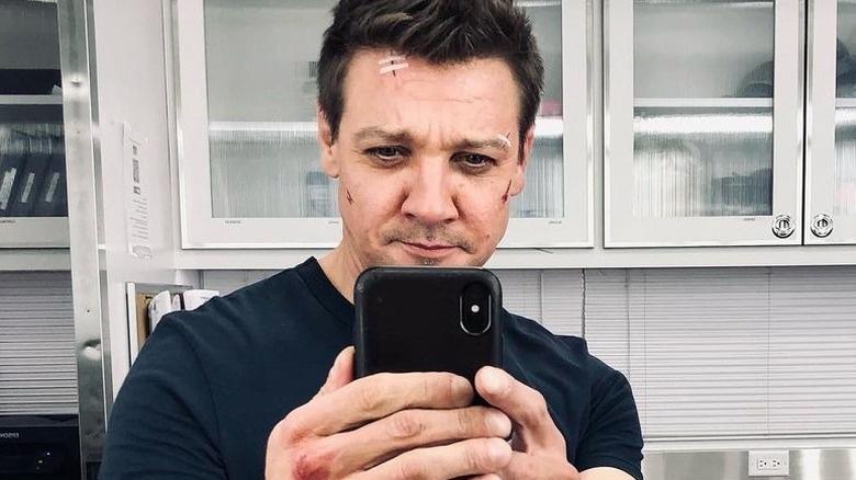 Jeremy Renner holding up phone