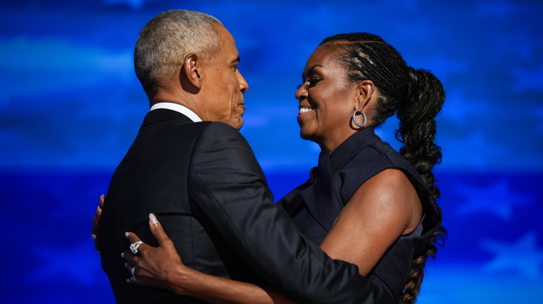 Former U.S. President Barack Obama greeting former first lady Michelle Obama as he arrives to speak on stage during the second day of the Democratic National Convention at the United Center