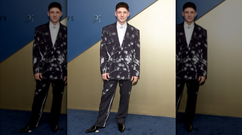 Chris Perfetti wearing a black suit with a blurry white print.
