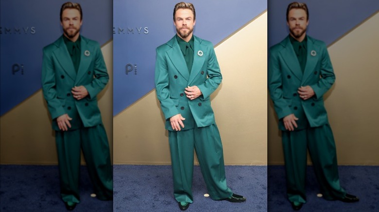 Derek Hough wearing a green suit.