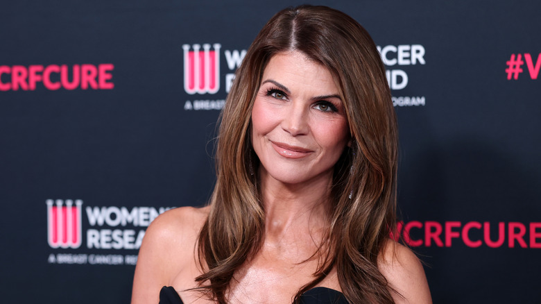 Close-up photo of Lori Loughlin smiling in a black dress.