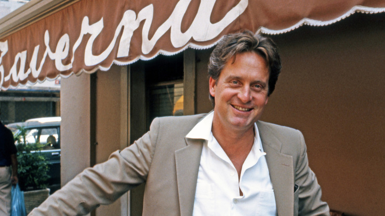 Michael Douglas in a tan suit, smiling