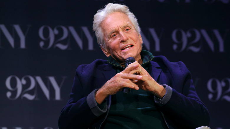 Michael Douglas speaking while holding a mic
