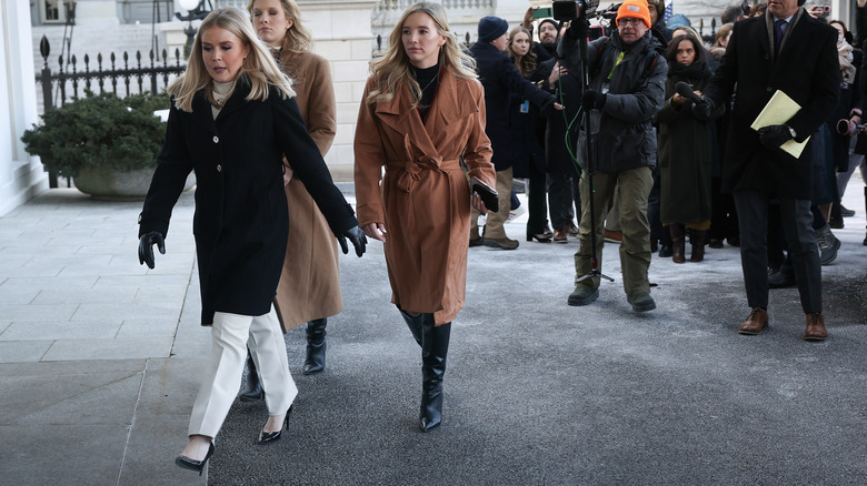 Karoline Leavitt walking to the White House followed by the press.
