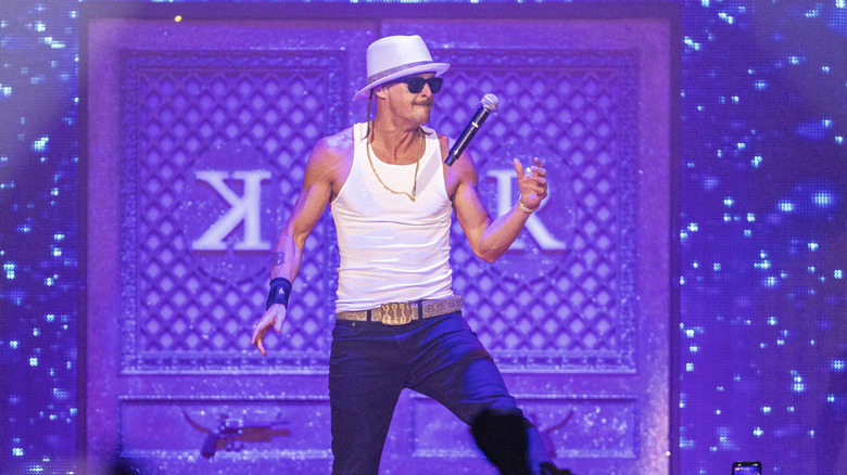 Kid Rock tosses a microphone up while performing.