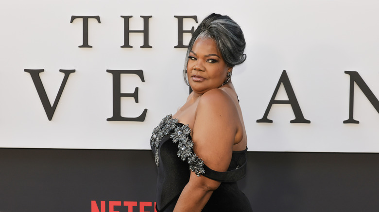 Mo'Nique looks over her shoulder in an off-the-shoulder black dress on the red carpet.