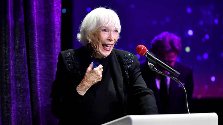Shirley MacLaine speaks animatedly on stage at the Dance Hall of Fame.