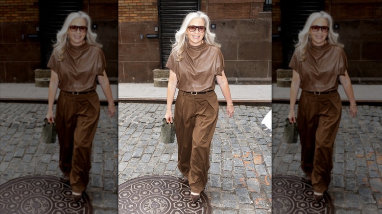 MJ Day smiling in a baggy brown top and matching trousers.