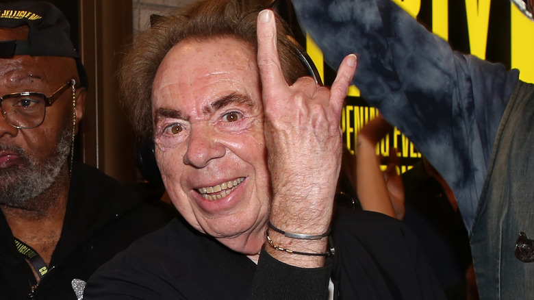 Andrew Lloyd Webber posing playfully while DJing at an event.