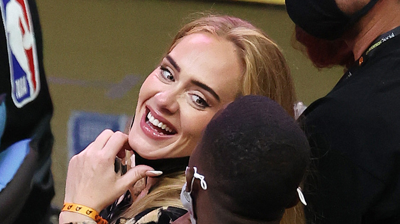 Adele laughing with Rich Paul at an NBA game