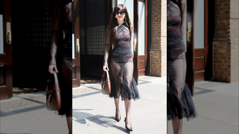 Dakota Johnson walking in New York City in a sheer, black dress