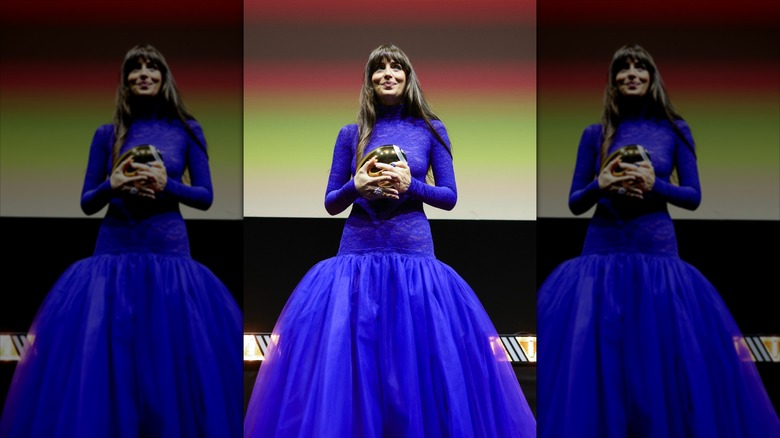 Dakota Johnson holding an award at the Zurich Film Festival in a sheer, blue dress