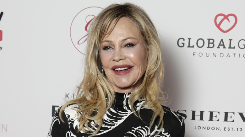 Melanie Griffith grinning and posing at charity event