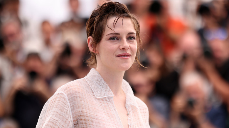 Kristen Stewart smiling in a collared shirt at Cannes 2026.