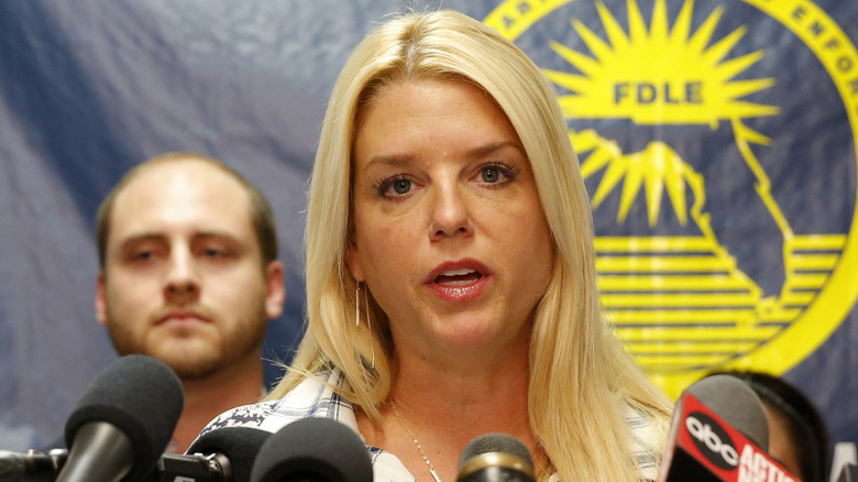 Pam Bondi speaking at a press conference and looking directly into the camera