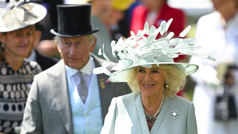 Camilla walking in front of Charles at the Royal Ascot