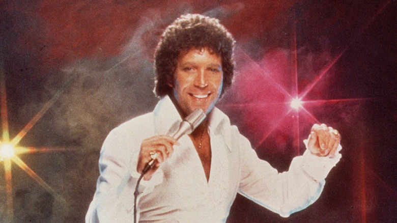 Tom Jones poses with a mic onstage in 1978.