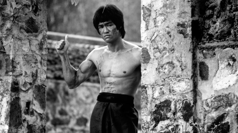 Bruce Lee posing, giving a thumbs up