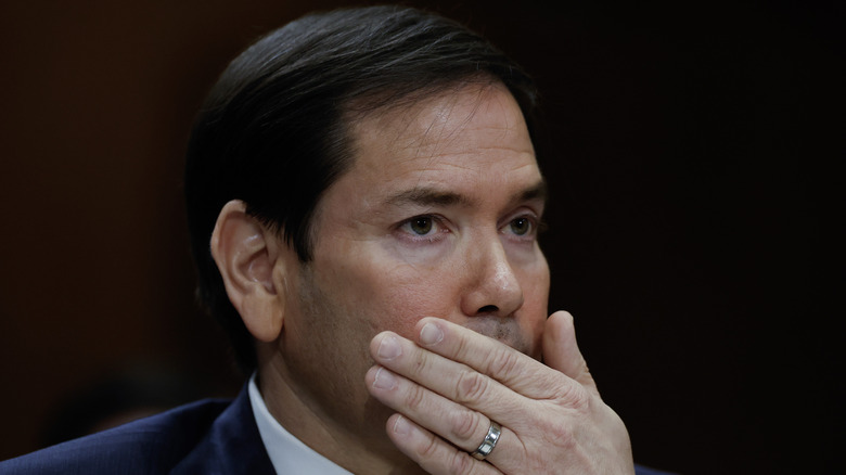 Marco Rubio covering his mouth with his hand during a hearing