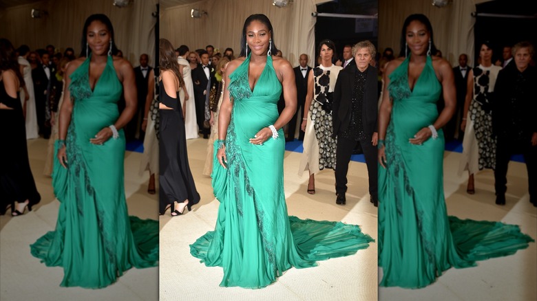 Serena Williams at the 2017 Met Gala in a green dress with a train and beading on one side.