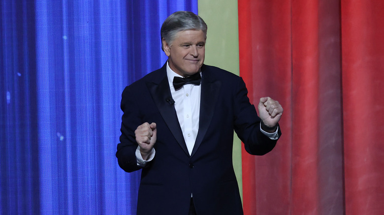 Sean Hannity in a tuxedo in front of blue and red curtains