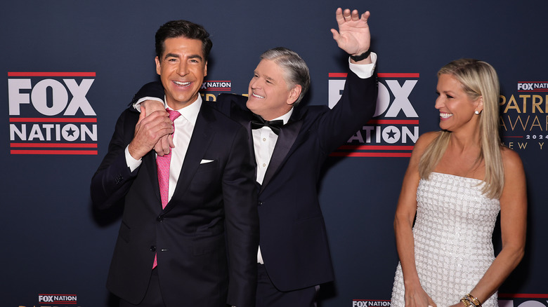 Ainsley Earhardt looks at Sean Hannity with his arm around Jesse Watters at a Fox Nation event