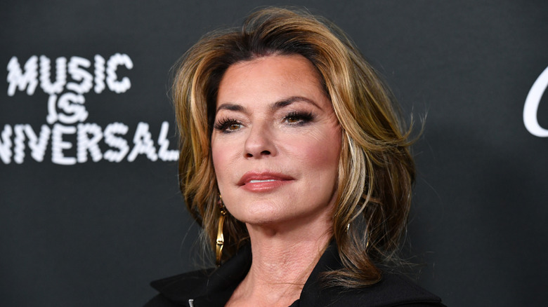 Shania Twain wearing huge gold earrings at a Grammys afterparty.