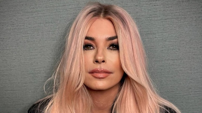 Shania Twain with pale pink hair and overlined pink lips.