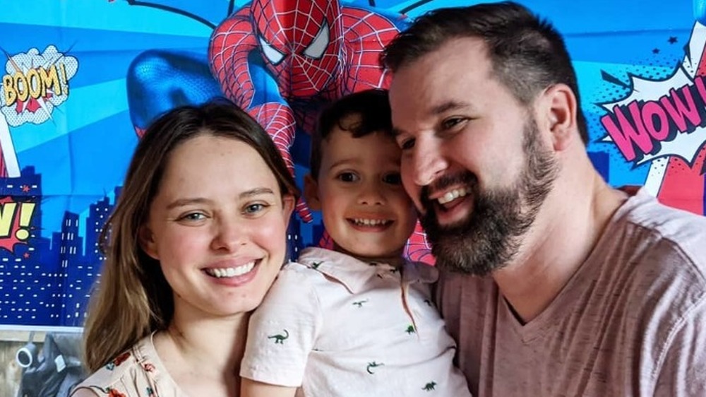 Alan and Kirlyam carries their son for a picture at a fair