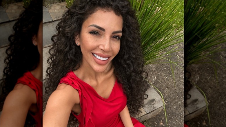 Jasmine Pineda takes a selfie while wearing a curly wig