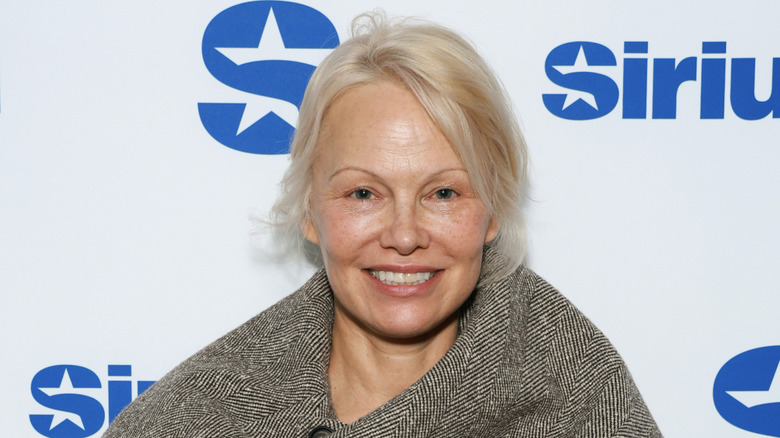 Pamela Anderson wearing a large parka and no makeup